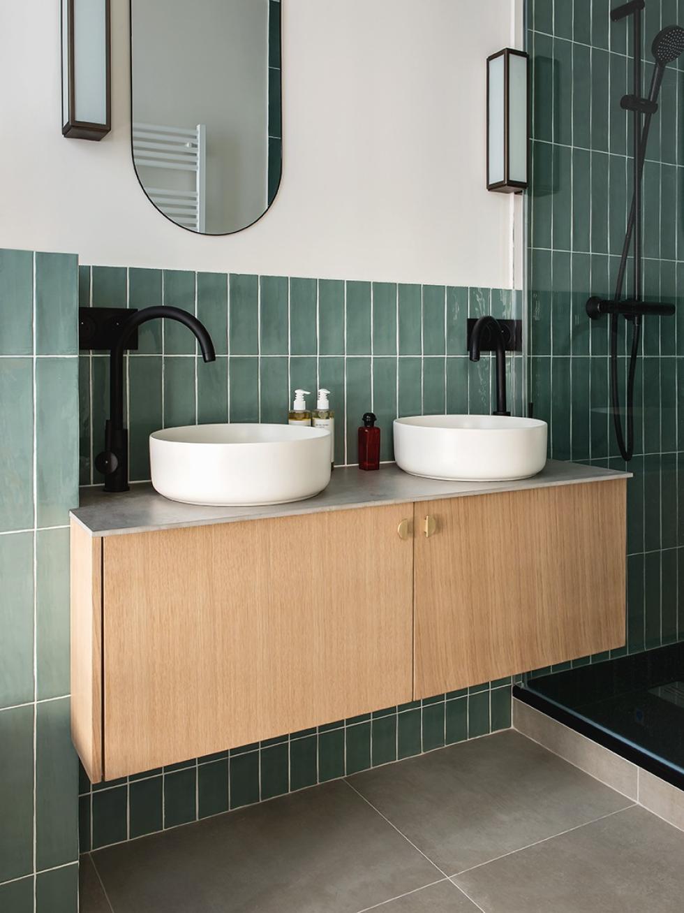 Natural oak wall-hung bathroom cabinet with green tiles