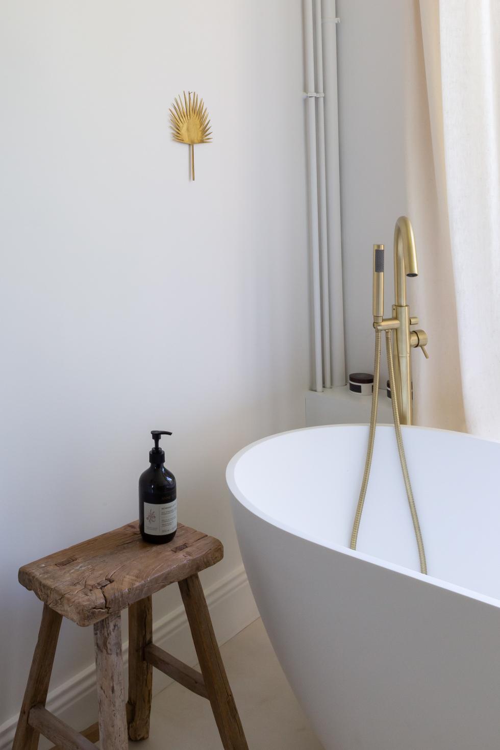 Bathtub with brass fittings and waxed concrete floor