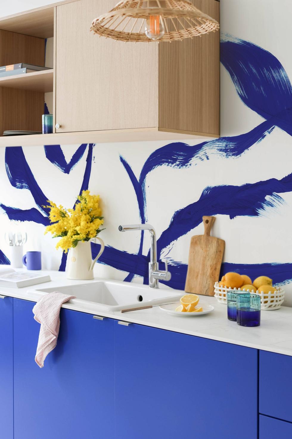 Kitchen in Electric Blue and Natural Oak with blue wallpaper.