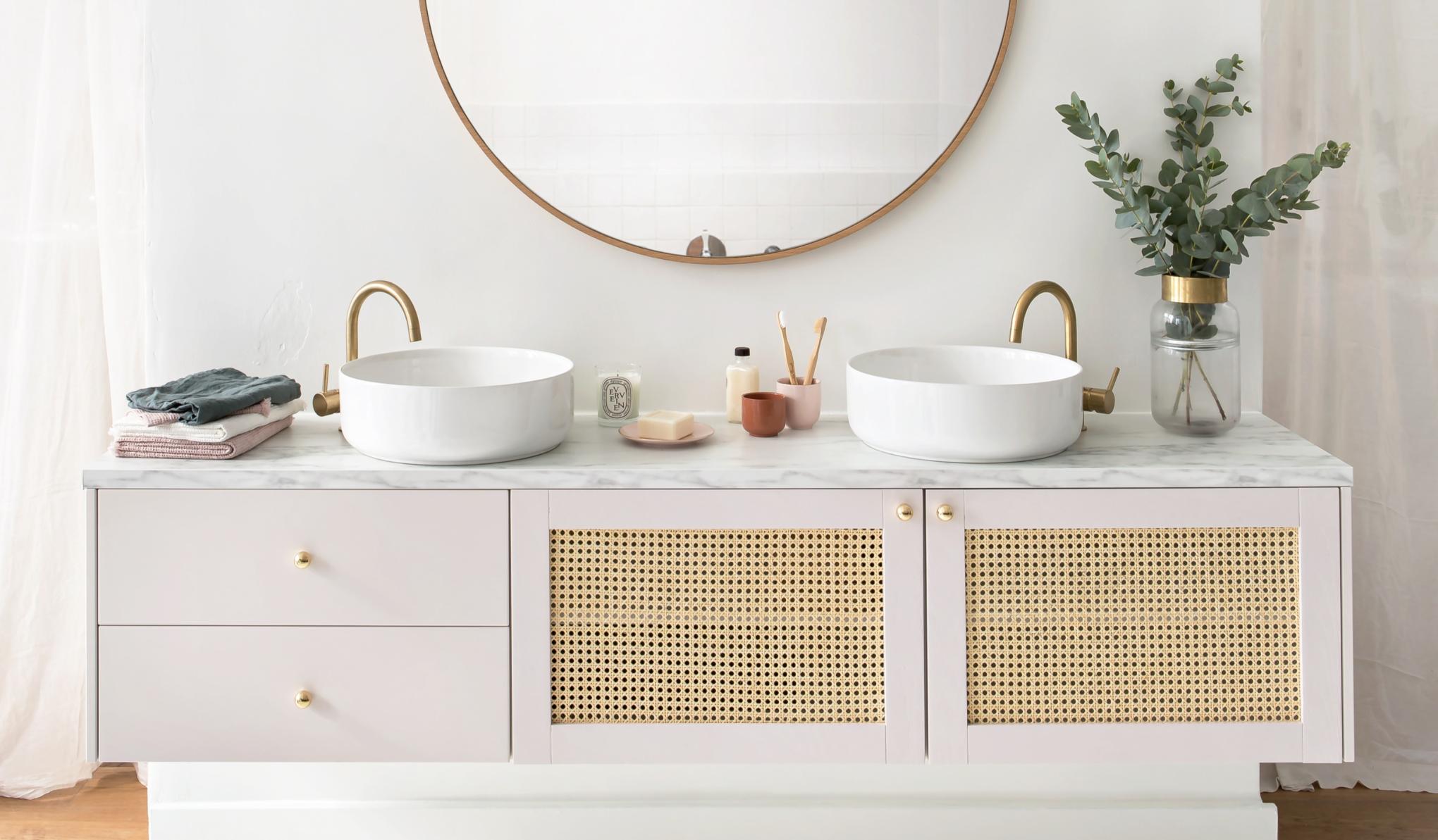 Wall-hung bathroom furniture with pink beige wicker fronts and brass accessories