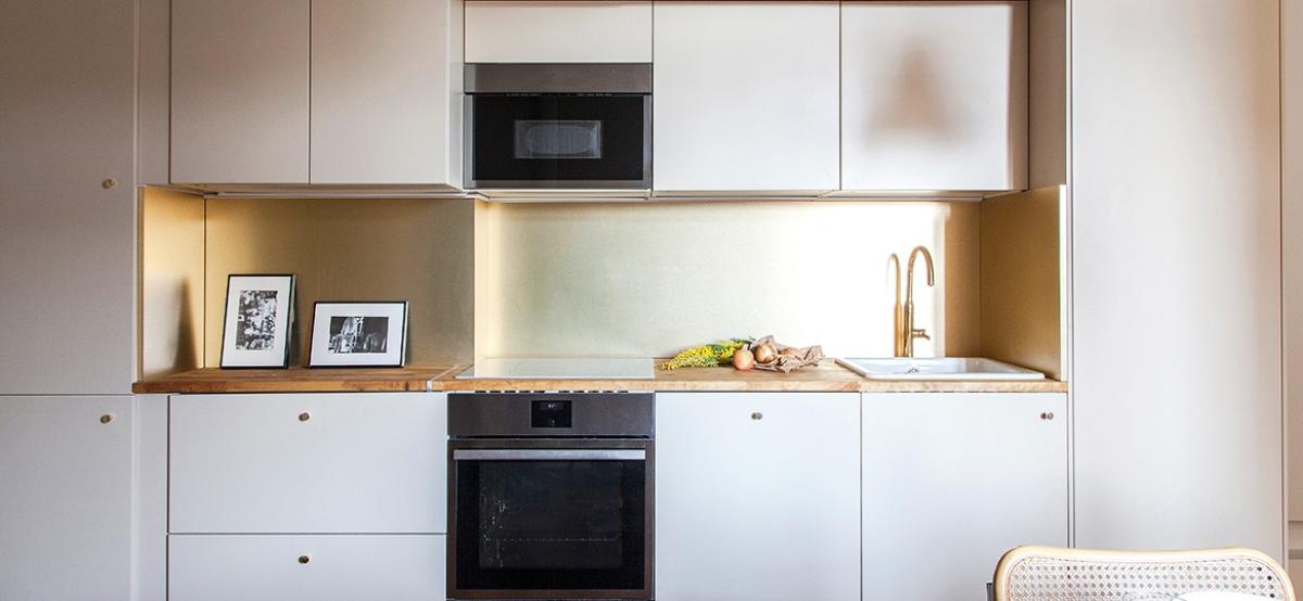 Kitchen in beige, brass splashback